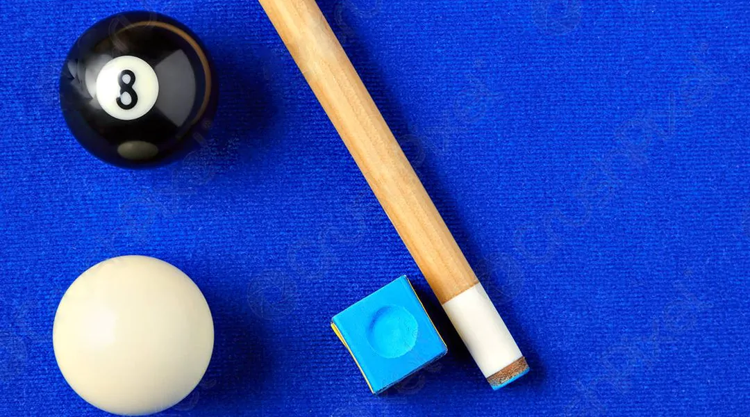 Bolas de billar y taco sobre paño azul
