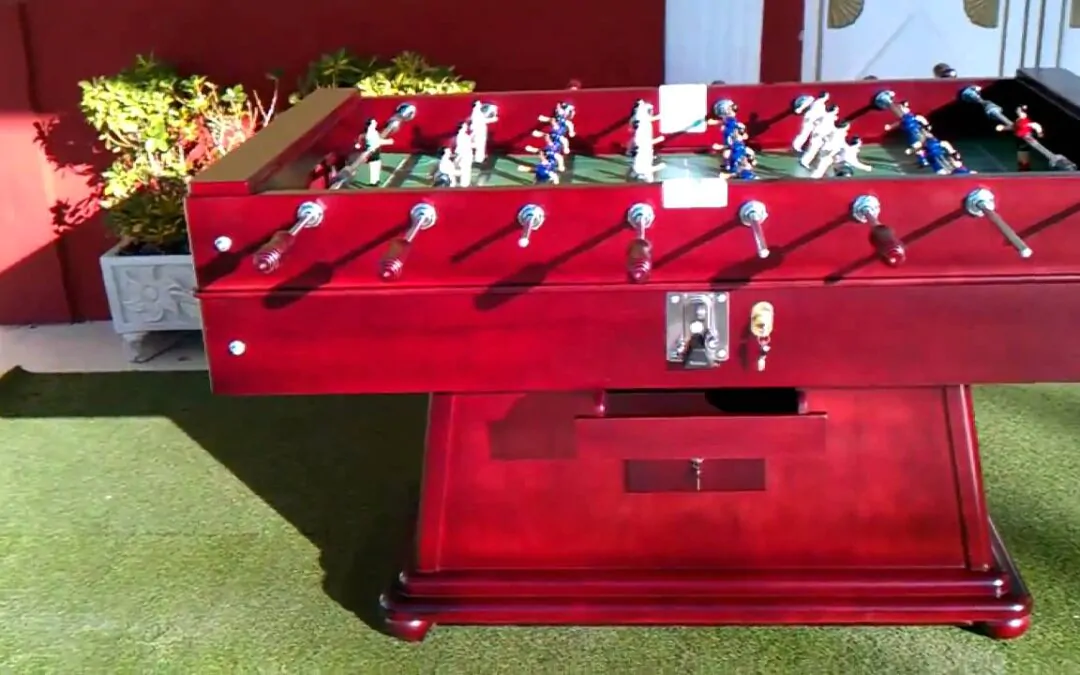 Futbolín de madera rojo en jardín