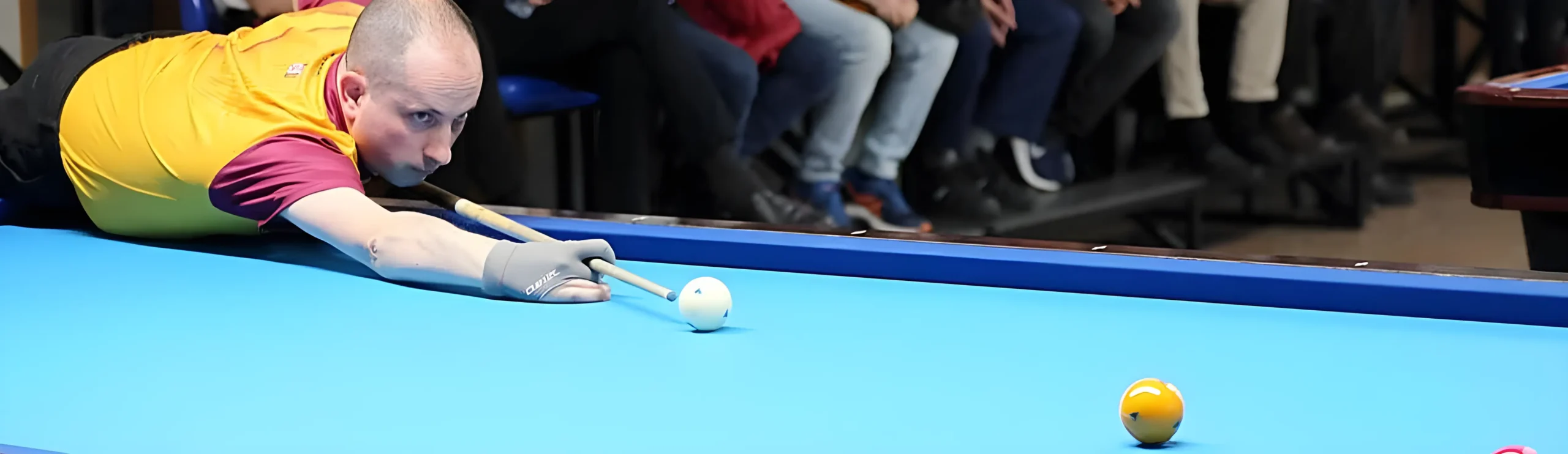 Alquiler de billares 3 Jugador de billar alineando tiro en mesa azul.