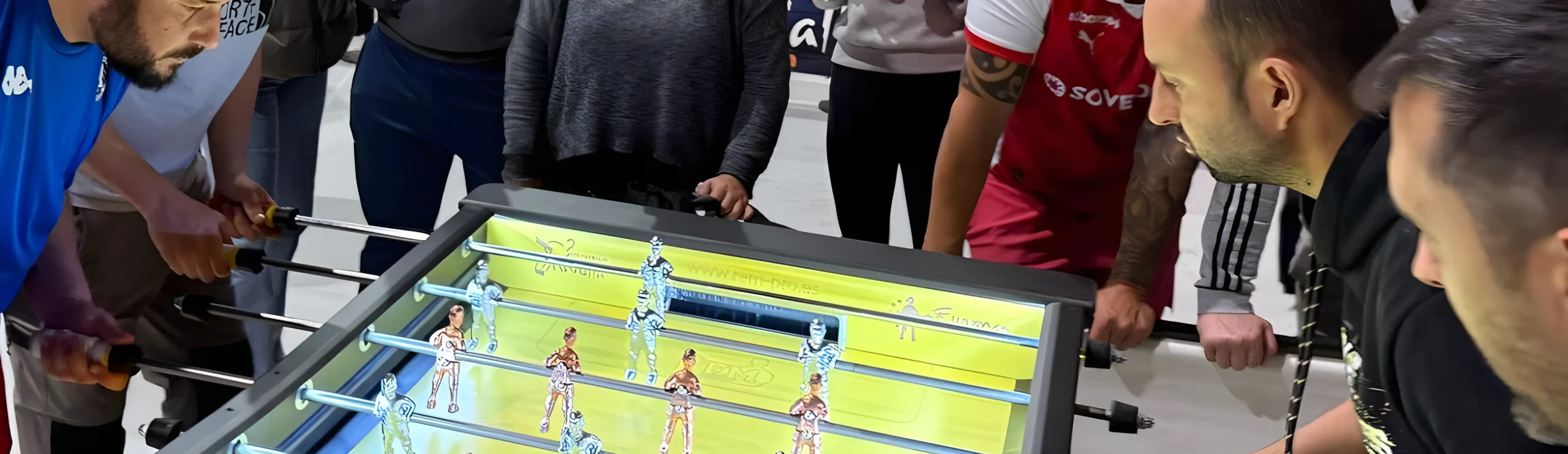 Alquiler de futbolines 2 Personas jugando al futbolín electrónico iluminado