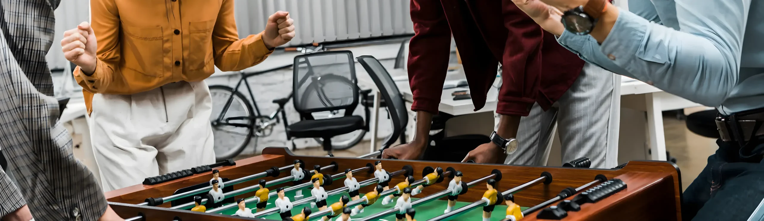 Personas jugando futbolín en oficina moderna