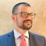 Hombre con gafas y traje formal sonriente