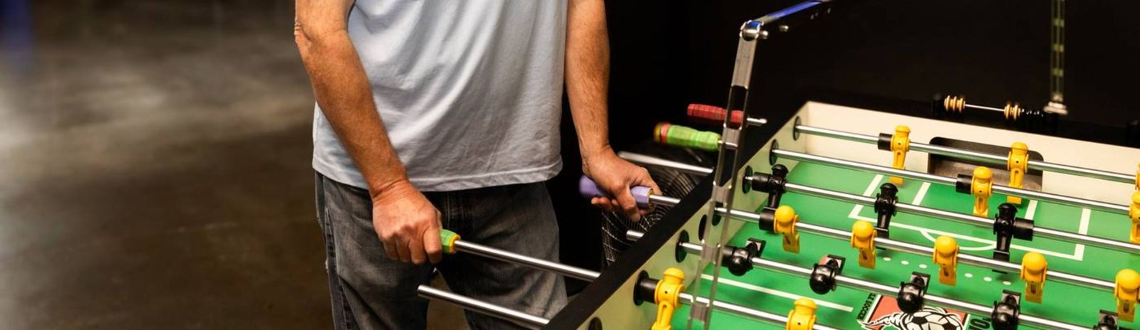 Persona jugando al futbolín en interior