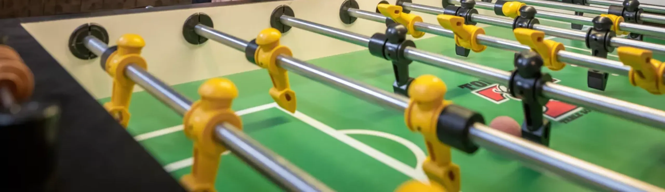 Mesa de futbolín con jugadores amarillos y negros